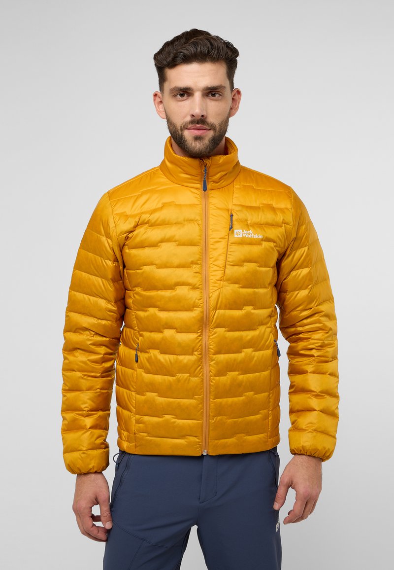 Giacca a vento gialla con motivo trapuntato, colletto alto e zip frontale. Presenta un logo sul petto ed è abbinata a pantaloni scuri.