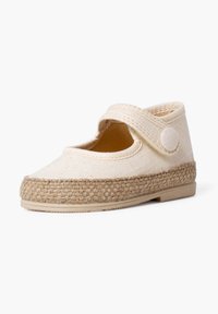 Beige fabric shoe with a round toe, strap closure, and woven jute sole. Smooth texture and minimalist design with stitched detailing.