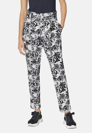 Zwart-witte bloemenprint broeken met zijzakken, getailleerde pasvorm en soepele stof. Gepaard met zwarte sneakers voor een casual look.