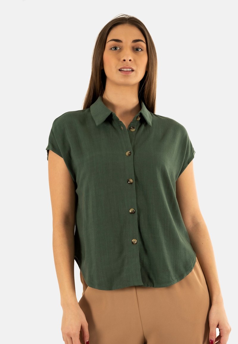 Blusa verde a maniche corte con frontale con bottoni, realizzata in tessuto leggero. Presenta un colletto classico e una texture sottile.