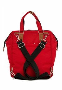 Red canvas bag with brown leather accents, two top handles, and adjustable black straps crossing at the back, featuring a zip closure and exterior pockets.