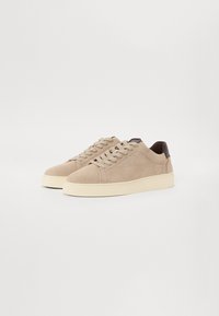 Sneakers bej din suede, cu talpă de cauciuc crem, cu vârf rotunjit, sistem de șireturi în față și accente din piele maro închis la călcâi.