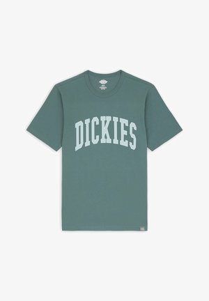 Groene katoenen T-shirt met korte mouwen, ronde hals en het "DICKIES"-logo in lichtblauw dat over de borst boogt. Glad oppervlak, casual ontwerp.