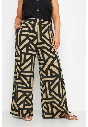Pantalones de pierna ancha en negro y beige que presentan patrones geométricos intersecados, tela suave, una cinta elástica en la cintura y bolsillos laterales.