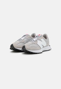Sneaker grigie chiare con tomaia in rete e suede, dettagli bianchi, lacci piatti e suola in gomma nera testurizzata per una buona aderenza.