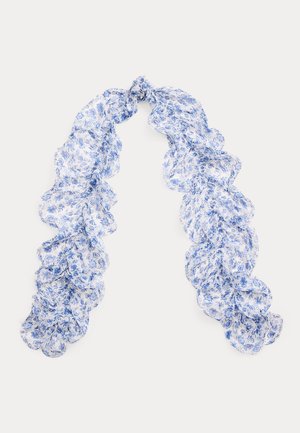 Let, gennemsigtigt tørklæde med blåt blomsterprint og flæser på kanterne, løst bundet øverst på en ensfarvet hvid baggrund.