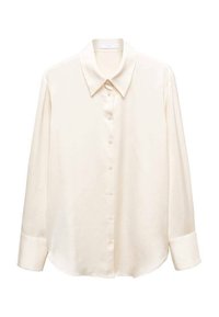 Chemise à manches longues couleur crème avec larges poignets et col pointu, présentée à plat sur fond blanc.
