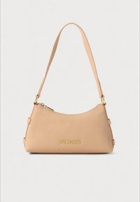 Pink leather handbag with a curved design, gold logo detailing, and a single adjustable strap; smooth texture and minimalist style.