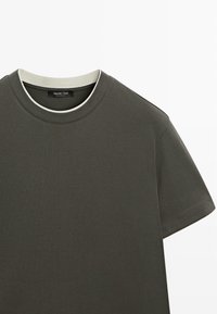 Donkergroen t-shirt met korte mouwen en een ronde hals, met een contrasterende lichte kraag en een gladde katoenen stof. Merketiket zichtbaar.