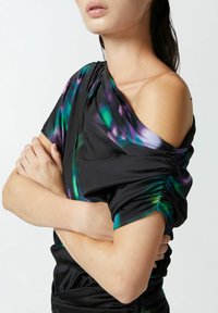 Crna majica s jednim izbačenim rukavom, nabrana tekstura, apstraktni uzorak u zelenoj i ljubičastoj boji. Meko, rastezljivo tkivo.