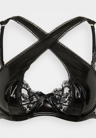 Black bra with glossy material and lace trim. Features crisscross straps and a central bow at the front. Notable for its mixed textures.