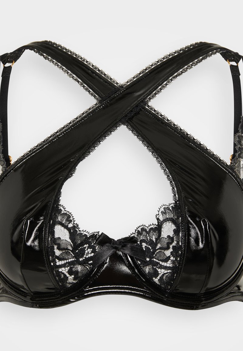 Black bra with glossy material and lace trim. Features crisscross straps and a central bow at the front. Notable for its mixed textures.