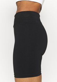 Čern�é cyklistické šortky s vysokým pasem z hladké elastické látky. Mají široký pas a přiléhavý střih, vhodné pro aktivní nošení.