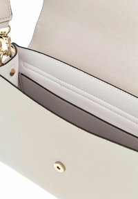 Sac en cuir blanc avec une texture grainée, doté d'une fermeture à bouton-pression en or et d'un intérieur spacieux avec un revêtement lisse.
