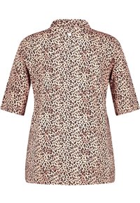 Blouse à imprimé léopard, manches courtes, tissu léger, fond rose pâle, taches noires et brunes, détail de col subtil.