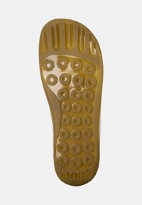 Semelle de chaussure en caoutchouc jaune avec des motifs texturés circulaires, des rainures et un arrière légèrement surélevé. Taille 38 gravée sur le côté.