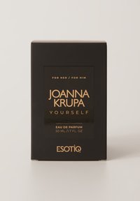 Czarny zapach w pudełku z złotym napisem "JOANNA KRUPA YOURSELF", z etykietą dla niej/nich, 50 ml, od ESOTIQ. Prosty, elegancki design.