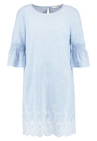 Blouse bleu clair à rayures avec ourlet en dentelle blanche festonnée et accents brodés. Comprend des manches courtes évasées et un dos à ouverture en forme de goutte.