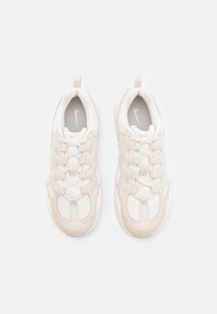 Scarpe da ginnastica bianche realizzate in un mix di materiali in rete e suede, con una forma arrotondata, un design leggero e dettagli testurizzati.