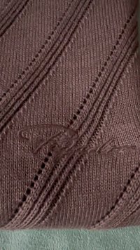 Trikotažas pastelinių mauve atspalvių su įstrižais raštais, turintis mažų skylių modelyje; subtilus iškilus logotipo detalė.