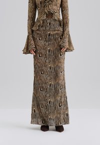 Vestido largo y ajustado en estampado de animal marrón y negro, con un escote con volantes y mangas acampanadas, confeccionado en una tela ligera y texturizada.