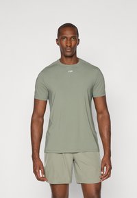 Korte mouwen sportshirt in zacht, olijfgroen stof met een ronde halslijn, voorzien van mesh-details en een klein logo op de borst.