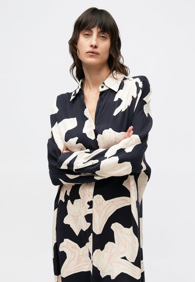 Πουκάμισο μακρυμάνικο σε ύφασμα ναυτικού μπλε με μεγάλα κρεμ λουλουδάτα σχέδια, με κουμπιά στο μπροστινό μέρος και άνετη εφαρμογή. Λείο υφή.