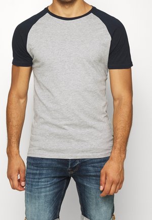 Graues Baumwoll-T-Shirt mit kurzen navy-farbenen Raglanärmeln, Rundhalsausschnitt und weicher Textur. Getragen mit lässigen blauen Jeans.