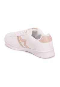 Zapatilla blanca con una franja de acento en oro rosa metálico y parte trasera, parte superior de sintético suave, suela de goma y cordones planos.