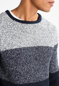 Dunkelblauer und grauer Strickpullover mit einem strukturierten Zickzackmuster, geripptem Halsausschnitt und Saum, der drei horizontale Farbstrukturen aufweist.