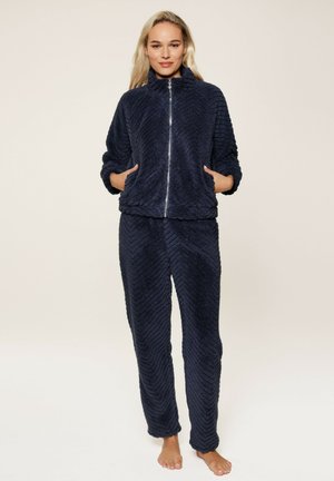 Navyblauw fleece loungewear set met een ritsjack met hoge kraag en een getextureerd chevronpatroon, gecombineerd met bijpassende broek.