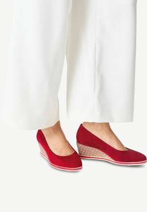 Punaiset samettiset wedges-karhulasit, joissa on vahva muotoilu, kangaspohjallinen jute-mallinen korko ja valkoinen kumipohja. Sileä pinta, jossa on minimaalinen koristelu.