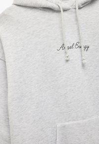 Hellgraue Kapuzenjacke aus weichem Stoff, mit einer Fronttasche, Kordelzug-Kapuze und "Angel Energy" in schwarzer Schreibschrift gestickt.