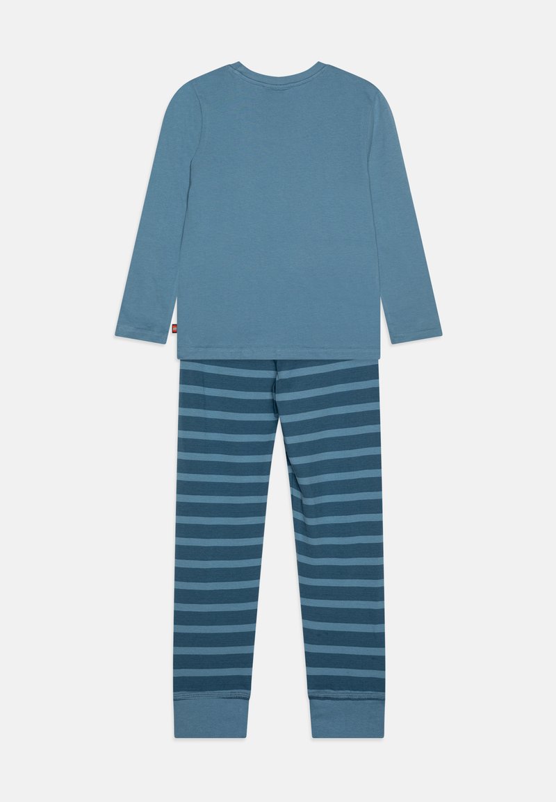 Blaues Langarmshirt kombiniert mit gestreiften blauen Schlafanzughosen. Weicher Stoff mit lässigem Schnitt, der kontrastierende horizontale Streifen aufweist.