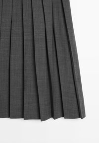 Gonna plissettata grigia realizzata in tessuto testurizzato, caratterizzata da pieghe uniformi e nette e da una finitura liscia. Messa in risalto da un taglio sartoriale.