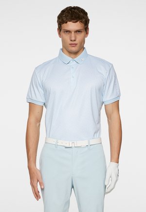 Light blue polo shirt with a subtle pattern, short sleeves, and a classic collar. Paired with light blue pants and a white belt, holding a white glove.