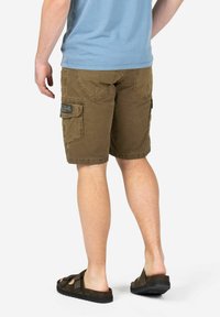 Brown cargo shorts with multiple pockets, a faded texture, and a relaxed fit, paired with dark brown sandals.