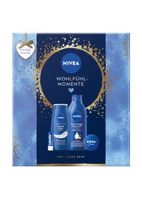NIVEA gift set in blue box with gold accents. Contains body milk, cream, and lip balm. Features white and blue packaging with product labels.