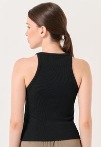 Schwarzes, geripptes Tanktop mit tailliertem Schnitt, breiten Schulterträgern und glatter Textur, von hinten präsentiert.