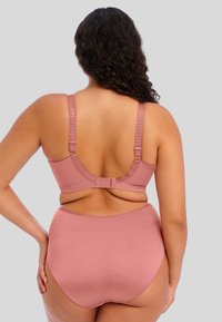 Conjunto de lingerie rosa com um tecido suave, alças largas ajustáveis e um fecho de gancho e olho nas costas; modelo de cueca alta.