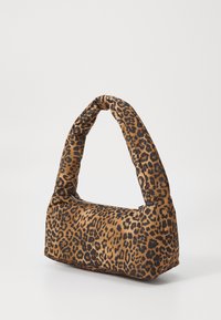 Sac à main en imprimé léopard avec une structure en tissu doux et rembourré, doté d'une poignée incurvée unique et d'une fermeture éclair. La palette de couleurs comprend des bruns et des noirs.