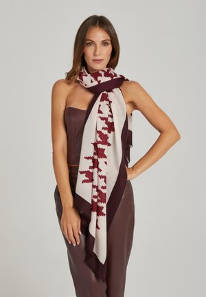 Bordeauxroter und cremefarbener Schal mit Muster, rechteckige Form und fransigen Rändern; leger um den Hals getragen und ein kontrastierendes Design präsentierend.