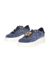 Sneakers platform in suede blu navy con suole bianche, occhielli dorati, lacci navy e una spilla decorativa con strass sulla scarpa destra.