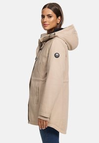 Parka beige à capuche avec une finition texturée, fermeture éclair à l'avant, cordon de serrage et badge sur la manche. Comprend des poches latérales et des poignets côtelés.