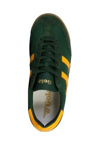 Grön och gul snörkänga med mocka- och tygpaneler, med varumärket "Gola" på tungan och innersulan.