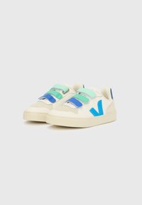 Sneakersy z górną częścią ze skóry w kremowo-białym kolorze, wyposażone w niebieskie i miętowe paski na rzep, perforowany nosek oraz kontrastowe niebieskie logo po boku.