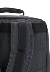 Svart denimryggsäck med texturerad tyg, sydda detaljer, dubbla bärremmar och en övre handtag för enkel transport.