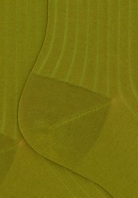 Rippensocken in Grün aus strukturiertem Stoff, mit glatter Oberfläche und nahtlosem Zehendesign, das Falten und Knitter zeigt.