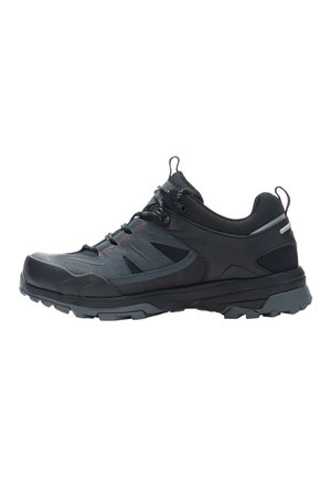 Zapatilla de senderismo negra y gris oscura con cierre de cordones, suela resistente y collar acolchado, mostrada en perfil lateral sobre fondo blanco.