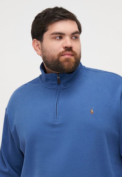 Blue fleece pullover, quarter-zip design, featuring a small embroidered logo on the chest and ribbed collar. Soft, smooth texture.